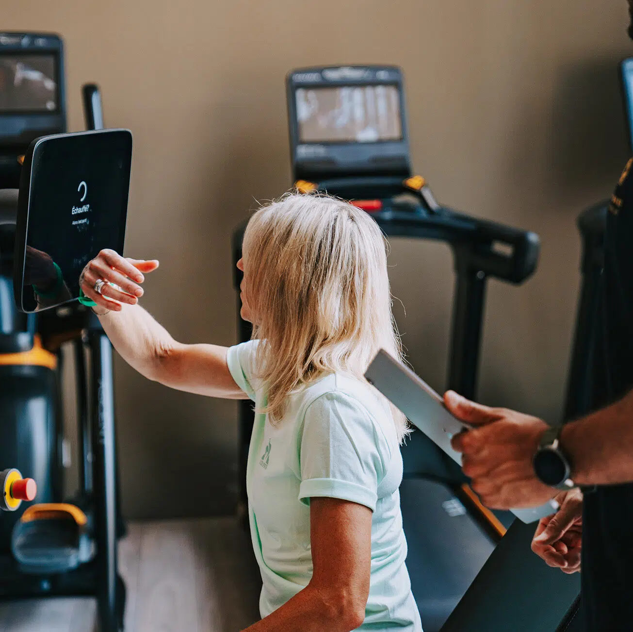 Un adhérent se connecte à une machine pour démarrer une session de coaching sportif au sein du Lodge coaching club dans les Monts d'Or